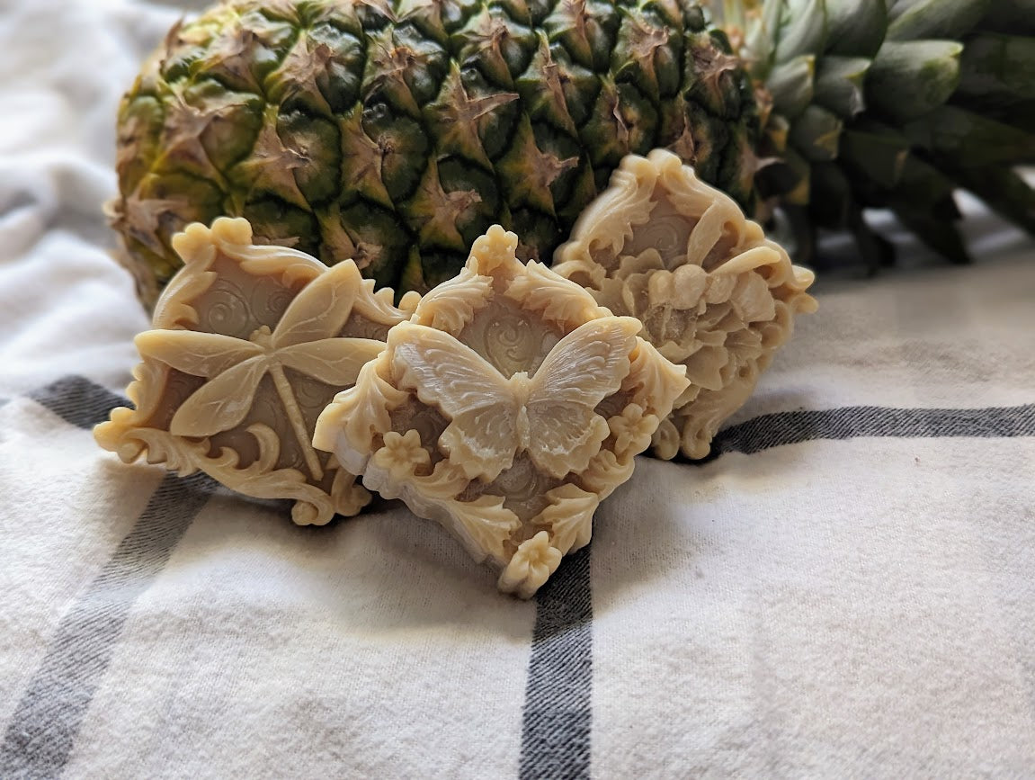 Three small square soaps with a dragonfly, butterfly and bee pictured